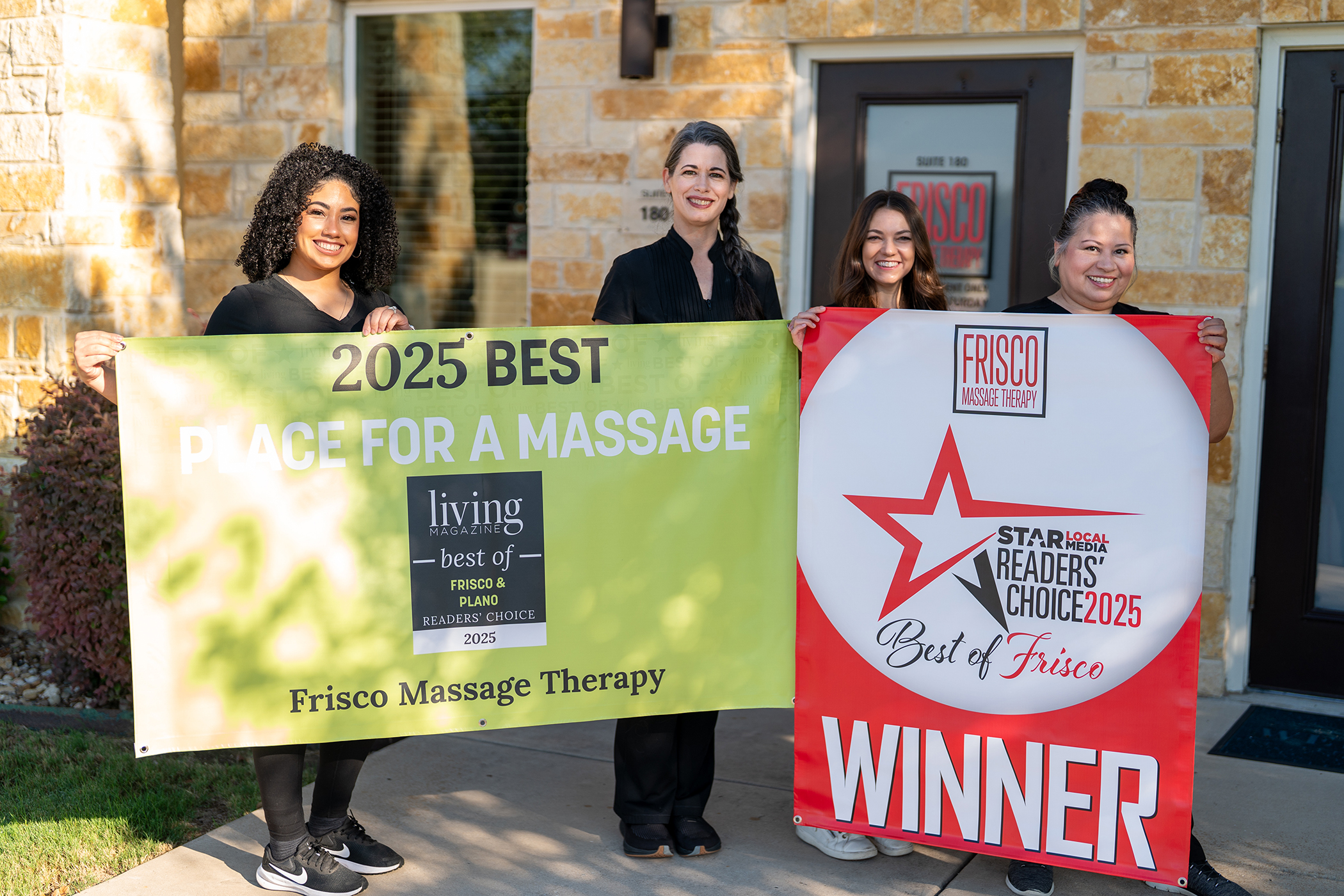 Four people stand outside holding banners that read “2025 Best Place for a Massage” and “Best of Frisco Winner,” celebrating Frisco Massage Therapy’s expertise in TMJ massage and neuromobility therapy.