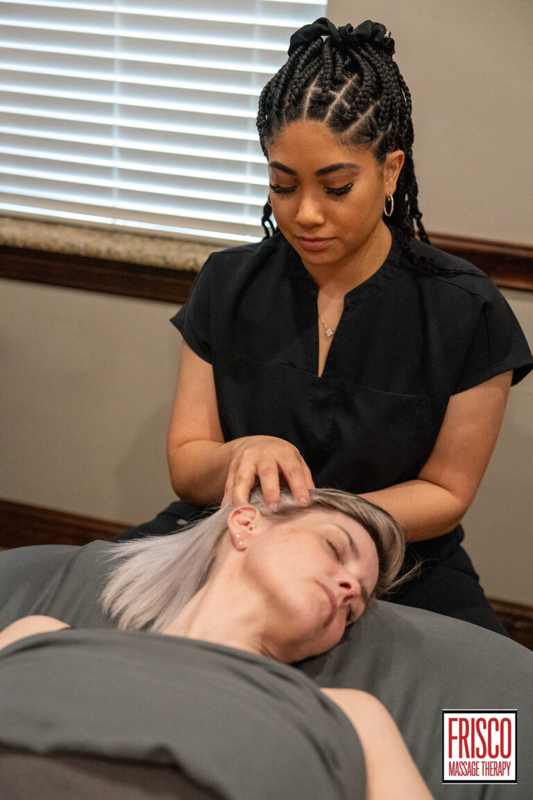 A massage therapist massages the head and neck of a client lying on a table in a spa room, offering relaxation and guidance on how to prepare for manual lymphatic drainage. The logo "Frisco Massage Therapy" is visible in the corner.