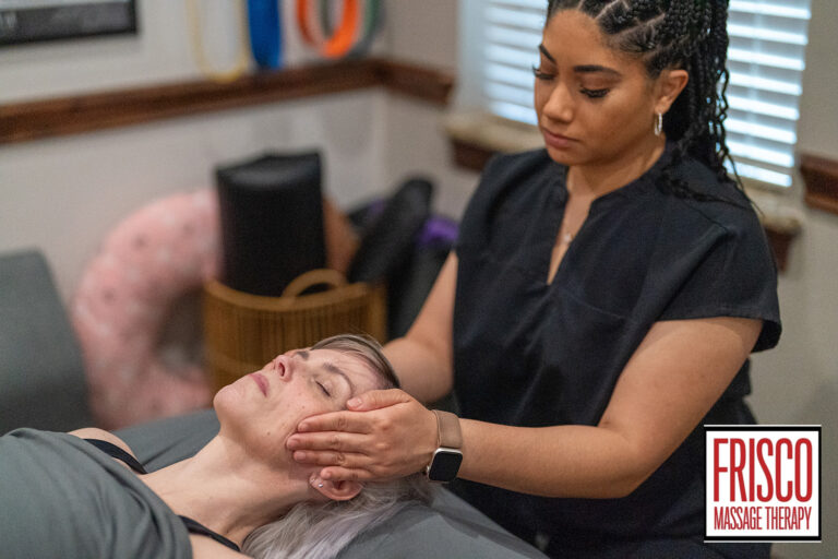 A massage therapist performs a therapeutic massage for jaw pain on a client lying on a table in a tranquil therapy room. The Frisco Massage Therapy logo is visible in the lower right corner.