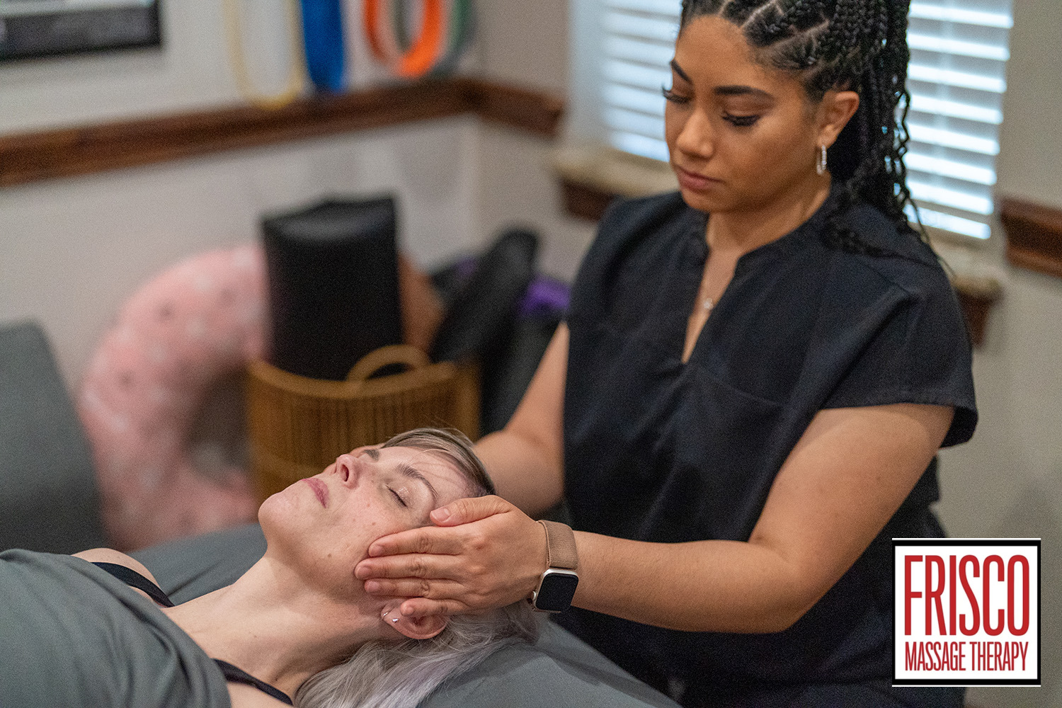 A massage therapist performs a head and neck massage focused on therapeutic massage for jaw pain in a calming treatment room. A Frisco Massage Therapy logo is visible in the lower right corner.